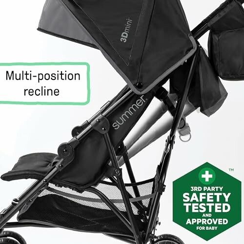 Side view of a black baby stroller with multi-position recline and safety approval badge.