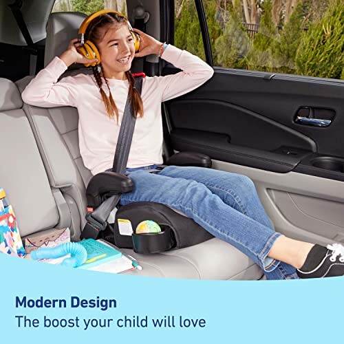 Child sitting in a car booster seat with headphones.