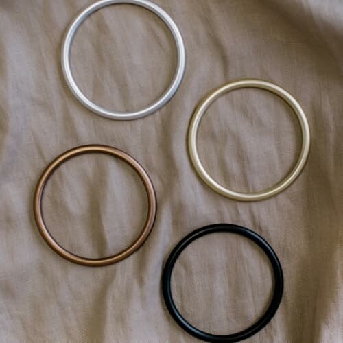 Four metallic bangles on fabric surface