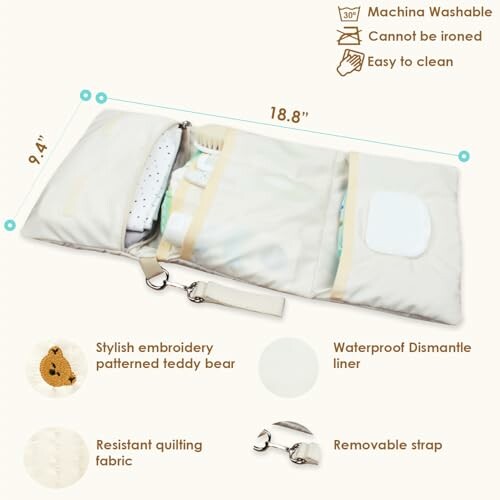 Portable baby changing mat with compartments, teddy bear embroidery, quilting fabric, and removable strap.