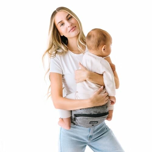 Woman in white t-shirt holding a baby with a hip seat carrier.